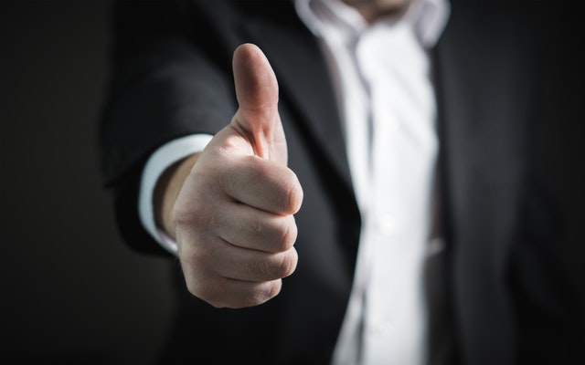 Close up of a thumb of a man wearing a black coat